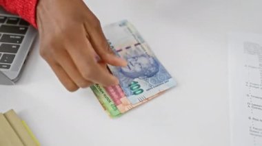 Modern ofis ortamında Güney Afrika Rand 'i işleten Afrikalı bir kadın.
