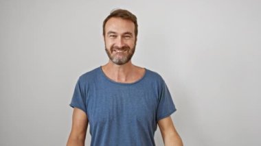 Beyaz tişörtlü heyecanlı İspanyol adam, sevinçle bağırıyor, gururla duruyor, kollarını kaldırıyor, zafer duygularını ifade ederken zafer kazanılıyor, beyaz arka planda izole edilmiş başarı.