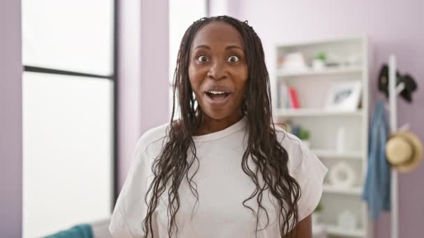 Afroamerykanka Kręconymi Włosami Wyrażająca Zaskoczenie Kolorowym Salonie — Wideo stockowe