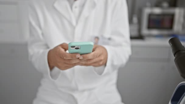 Ein Fokussierter Männlicher Wissenschaftler Weißen Laborkittel Untersucht Ein Smartphone Einem — Stockvideo