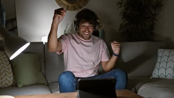 Ένας Χαρούμενος Άνθρωπος Ακουστικά Γιορτάζει Ένα Άνετο Σαλόνι Που Ενσωματώνει — Αρχείο Βίντεο