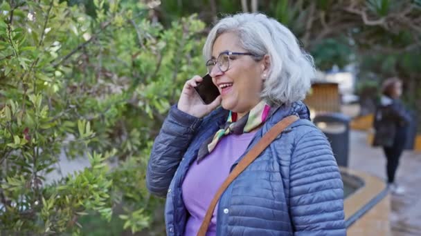 Mujer Madura Feliz Con Gafas Hablando Por Teléfono Exuberante Entorno — Vídeo de stock