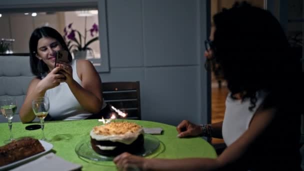 两个女人在一个舒适的餐厅里 用蛋糕和葡萄酒庆祝 一个用智能手机捕捉这个时刻 — 图库视频影像