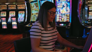 Canlı bir kumarhanede kumar oynayan genç bir kadın kumar oynamanın heyecanını yayıyor..