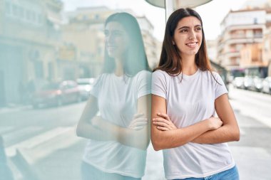 Sokakta kollarını kavuşturmuş genç, güzel İspanyol bir kadın.