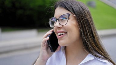 Genç ve güzel İspanyol kadın gülümsüyor. Madrid sokaklarında telefonda mutlu bir şekilde konuşuyor.