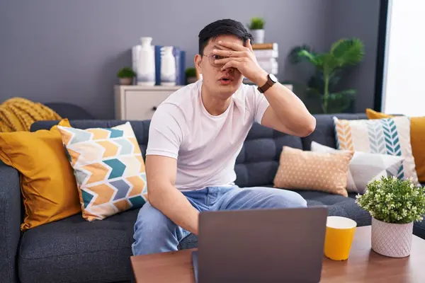 Young Asian Man Using Laptop Home Sitting Sofa Peeking Shock — Stock Photo, Image