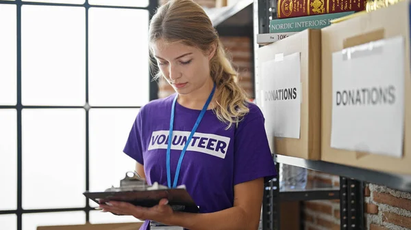 Jovem Loira Voluntária Escrevendo Lista Verificação Centro Caridade — Fotografia de Stock