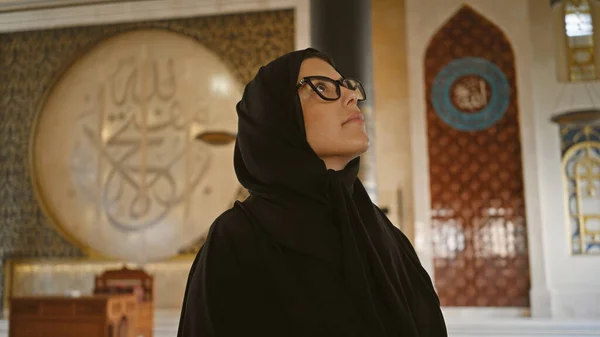 一位身穿伊斯兰传统服饰的成年黑发女子欣赏道哈清真寺内复杂的阿拉伯书法 — 图库照片