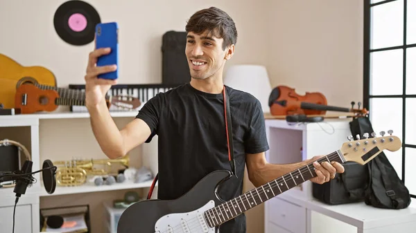 Sonriente Joven Hispano Músico Rockstar Electrifica Habitación Haciendo Una Selfie —  Fotos de Stock