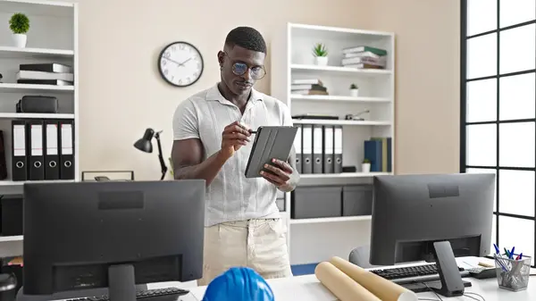 African american man architect drawing on touchpad thinking at the office