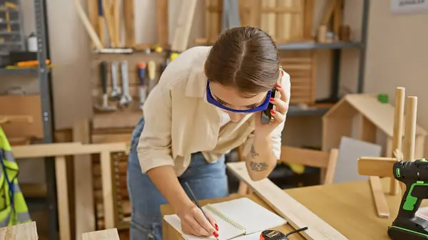 Young Brunette Woman Talks Phone While Taking Notes Indoor Carpentry — Stock Photo, Image
