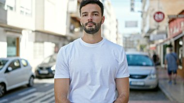 Sokakta ciddi bir ifadeyle duran İspanyol genç adam.