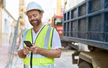 Sokaklarda akıllı telefon kullanan orta yaşlı bir mimar.