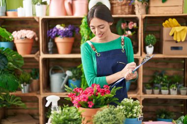 Çiçekçide kendine güvenen güzel İspanyol kadın çiçekçi.