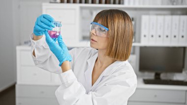 Laboratuvarda test tüpüne bakan genç ve güzel İspanyol bilim kadını.