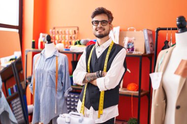 Genç İspanyol terzi gülümsüyor. Kollarını kavuşturup atölyeye bakıyor.