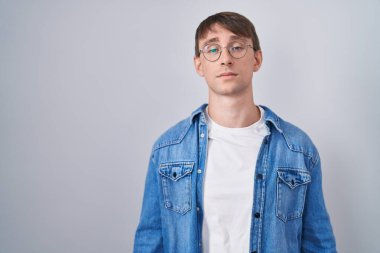 Beyaz, sarışın, gözlüklü, uykulu ve yorgun görünen, yorgunluktan bitkin düşmüş, akşamdan kalma, tembel gözlü bir adam.. 