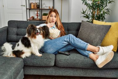 Beyaz bir kadın evde köpekle birlikte kanepede oturup film izlerken şaşırdı.