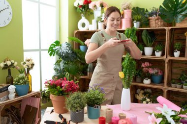 Çiçekçide çiçekçiyle fotoğraf çektiren güzel bir kadın.