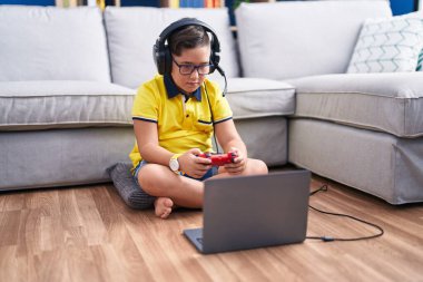 Sevimli İspanyol çocuk evde oturmuş video oyunu oynuyor.
