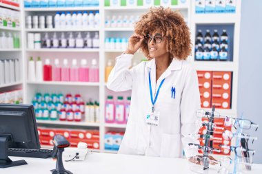 Eczanede kendine gülen Afrikalı Amerikalı kadın eczacı.