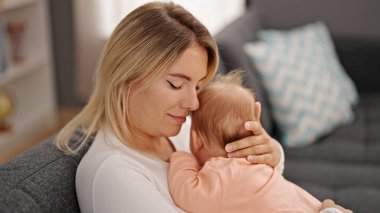 Anne ve kızı evde birbirlerine sarılıyorlar.