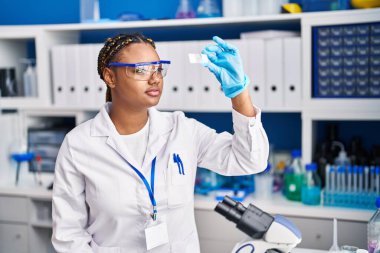African american woman scientist looking sample at laboratory