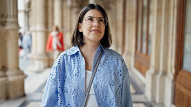 Genç, güzel, İspanyol bir kadın gülümseyerek Viyana sokaklarına bakıyor.