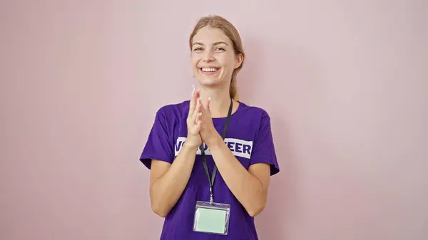 Młoda Blondynka Wolontariuszka Uśmiecha Się Pewnie Klaszcząc Dłonie Odizolowanym Różowym — Zdjęcie stockowe