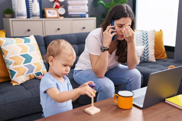 Mother and son stressed talking on smartphone playing at home