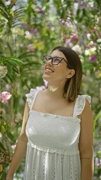 Happy hispanic woman in glasses, an immersive exploration of futuristic plant exhibition at a colourful, modern museum