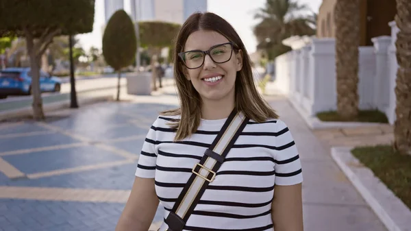 Улыбающаяся Женщина Очках Позирующая Современной Улице Абу Даби Демонстрирующая Городскую — стоковое фото
