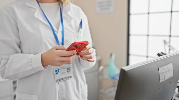 臨床設定でスマートフォンを使用したラボコートの女性ヘルスケアの専門家 ウィンドウでバックライト — ストック写真