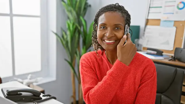 Smiling African Woman Professional Attire Using Phone Modern Office Setting — Stock Photo, Image