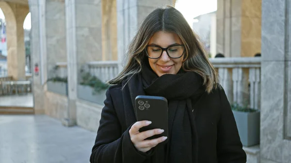 Eine Lächelnde Junge Frau Checkt Ihr Smartphone Auf Einer Straße — Stockfoto