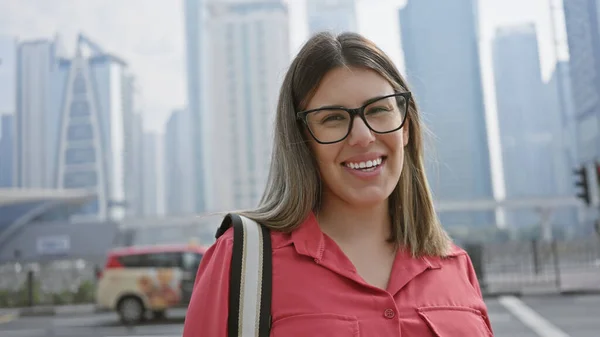 在现代的杜拜城市摩天大楼前微笑着年轻的惊慌失措的女人 — 图库照片