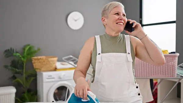 Middle Age Grey Haired Woman Talking Smartphone Ironing Clothes Laundry — Stock Photo, Image
