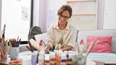 Neşeli genç İspanyol kadın sanatçı stüdyodaki kanepeden galibiyet ve heyecan dolu bir kutlama aldı.