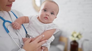 Salon draması, üniformalı bir çocuk doktoru kucağında hasta bir bebek, ciddi görünüyor ama yatak odası muayenesinde rahat görünüyor, yetişkin bir kadın sıradışı bir aşk yaşıyor.