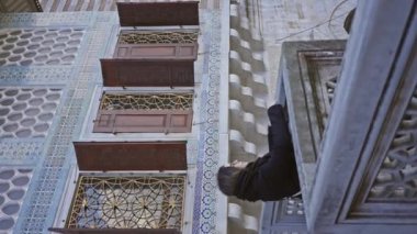 Genç bir kadın İstanbul 'un tarihi mimarisini keşfediyor. Süslü bir taş korkuluğa yaslanıyor..