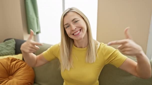 Sebevědomá Mladá Blondýnka Tričku Ukazuje Sebe Pyšně Vypadá Šťastně Interiéru — Stock video