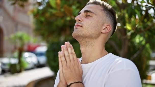 Спокойный Молодой Человек Медитирует Открытом Воздухе Закрытыми Глазами Соединенными Руками — стоковое видео