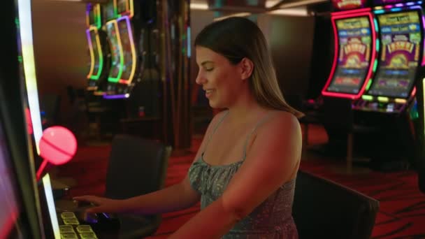 Μια Χαμογελαστή Γυναίκα Παίζει Κουλοχέρηδες Ένα Καζίνο Αποπνέοντας Χαρά Και — Αρχείο Βίντεο