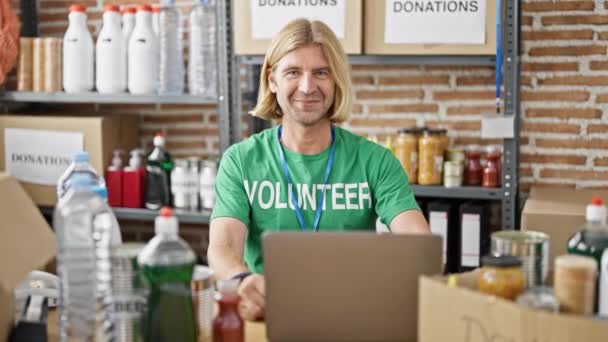 Lächelnder Mann Einem Zentrum Für Lebensmittelspenden Hinter Einem Laptop Stehend — Stockvideo