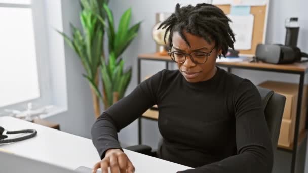 令人惊讶的年轻黑人妇女 办公室里有可怕的头发 她怀疑地在笔记本电脑上工作 震惊地表情 挖苦地张开嘴 — 图库视频影像
