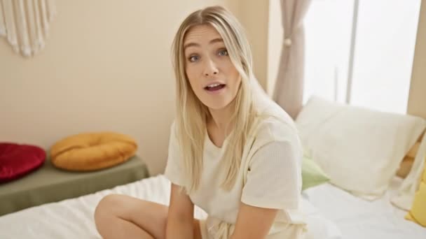 Скептически Настроенная Молодая Блондинка Пижаме Сидящая Кровати Саркастическим Взглядом Открытый — стоковое видео