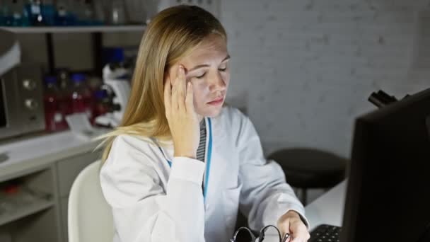 Eine Blonde Wissenschaftlerin Einem Labor Die Neben Computergeräten Ihre Brille — Stockvideo