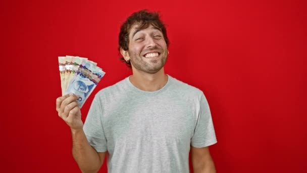 Veselý Mladý Muž Kanadskými Dolarovými Bankovkami Sebevědomě Ukazuje Prstem Vzhůru — Stock video