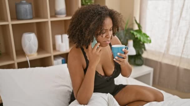 アフリカ系アメリカ人女性 電話を使用してブレードを持ち 寝室でマグカップを保持 — ストック動画